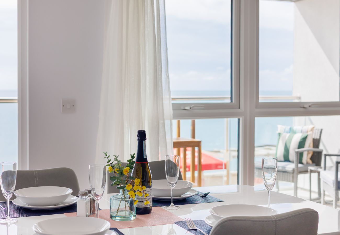 Modern dining area with table and chairs overlooking the sea at Culver Sands, Isle of Wight