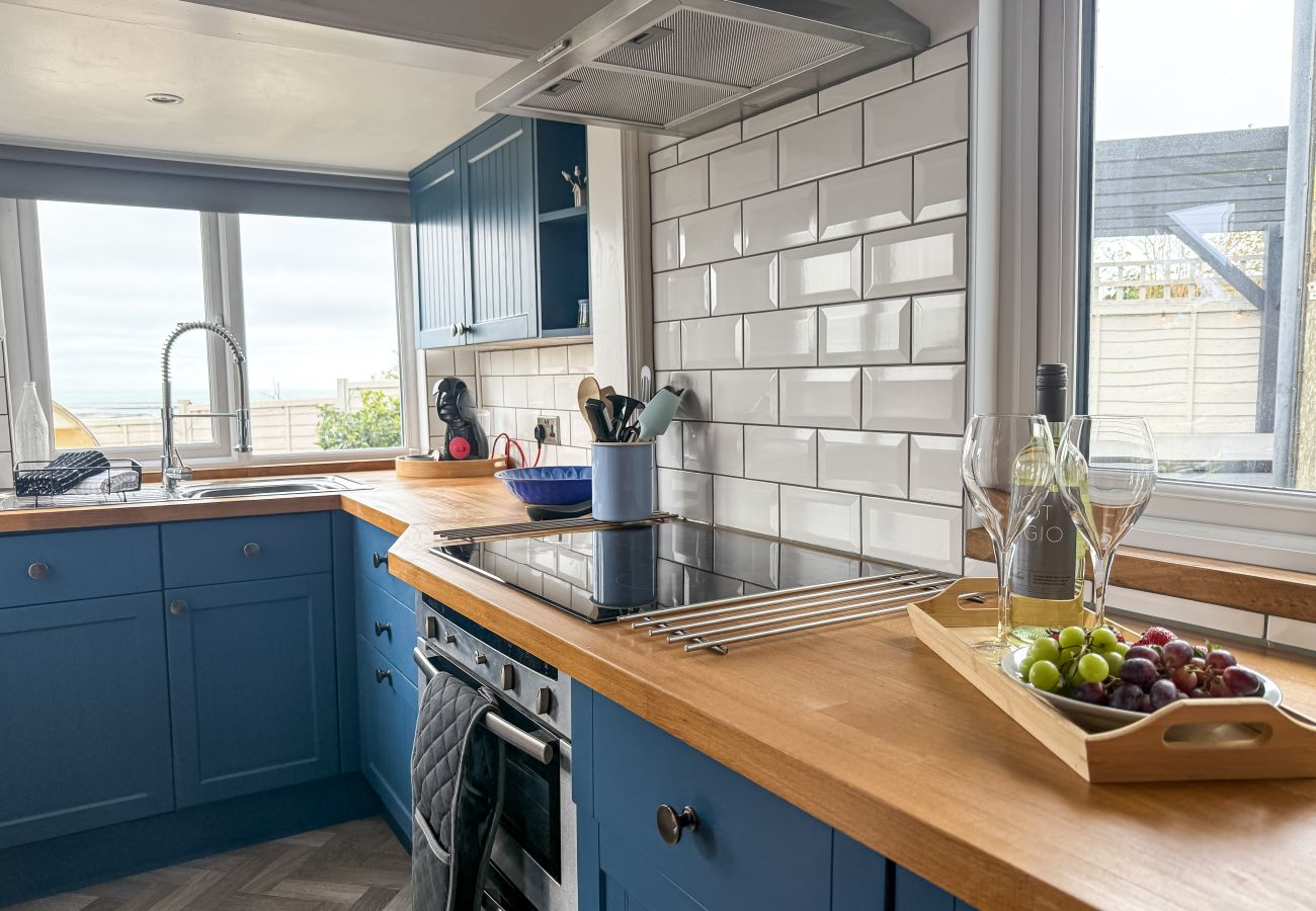 Contemporary fully equipped kitchen at Red Cedars with sleek cabinetry, high-spec appliances, and open-plan access to the dining and living area