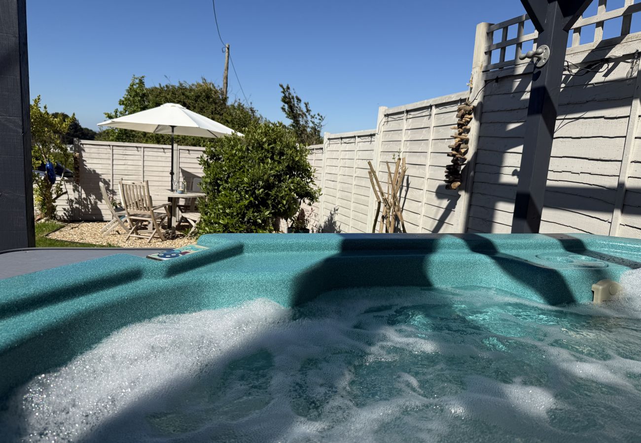 Outdoor hot tub with garden views at Red Cedars holiday cottage