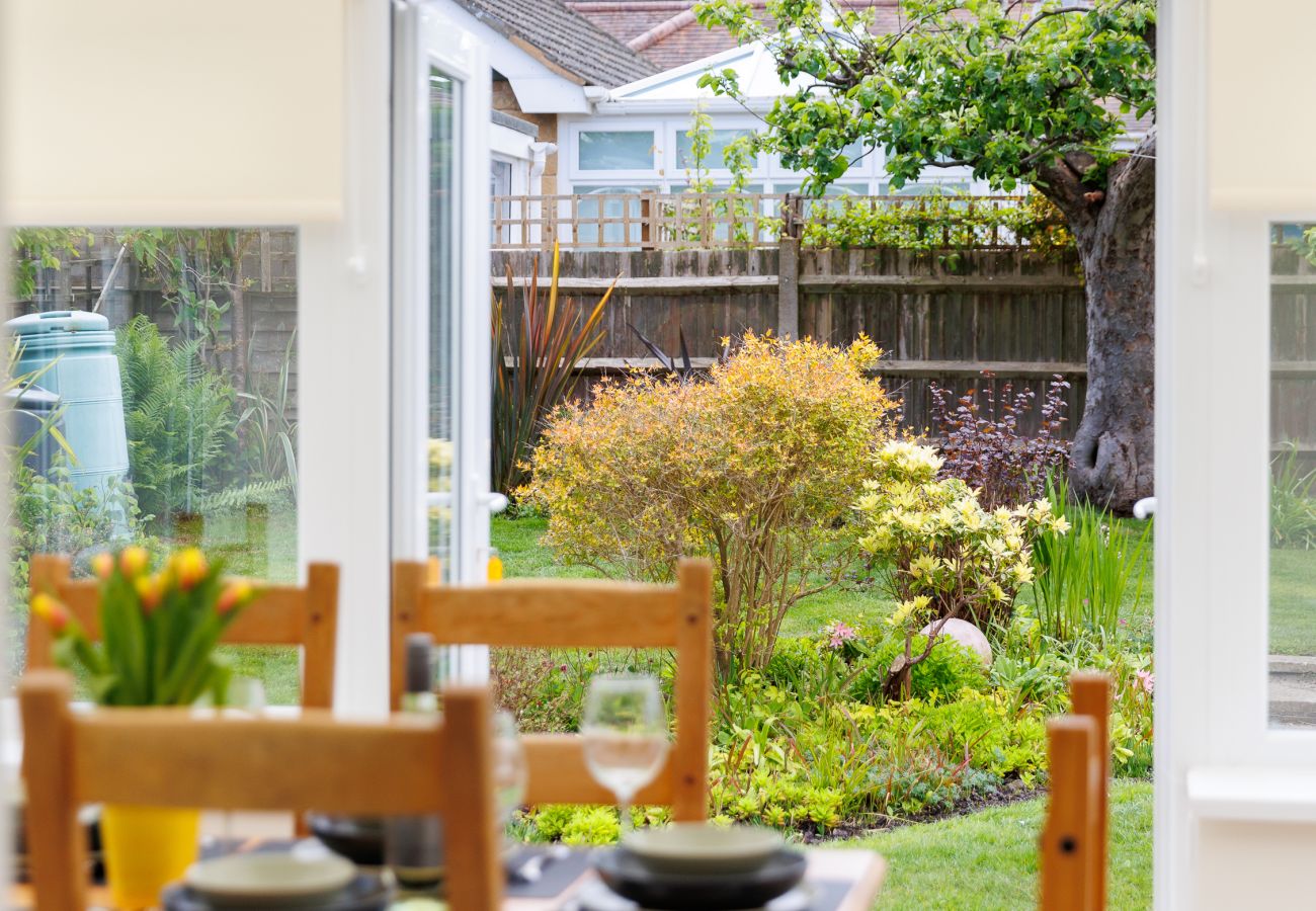 Modern holiday home dining table looking into outdoor garden