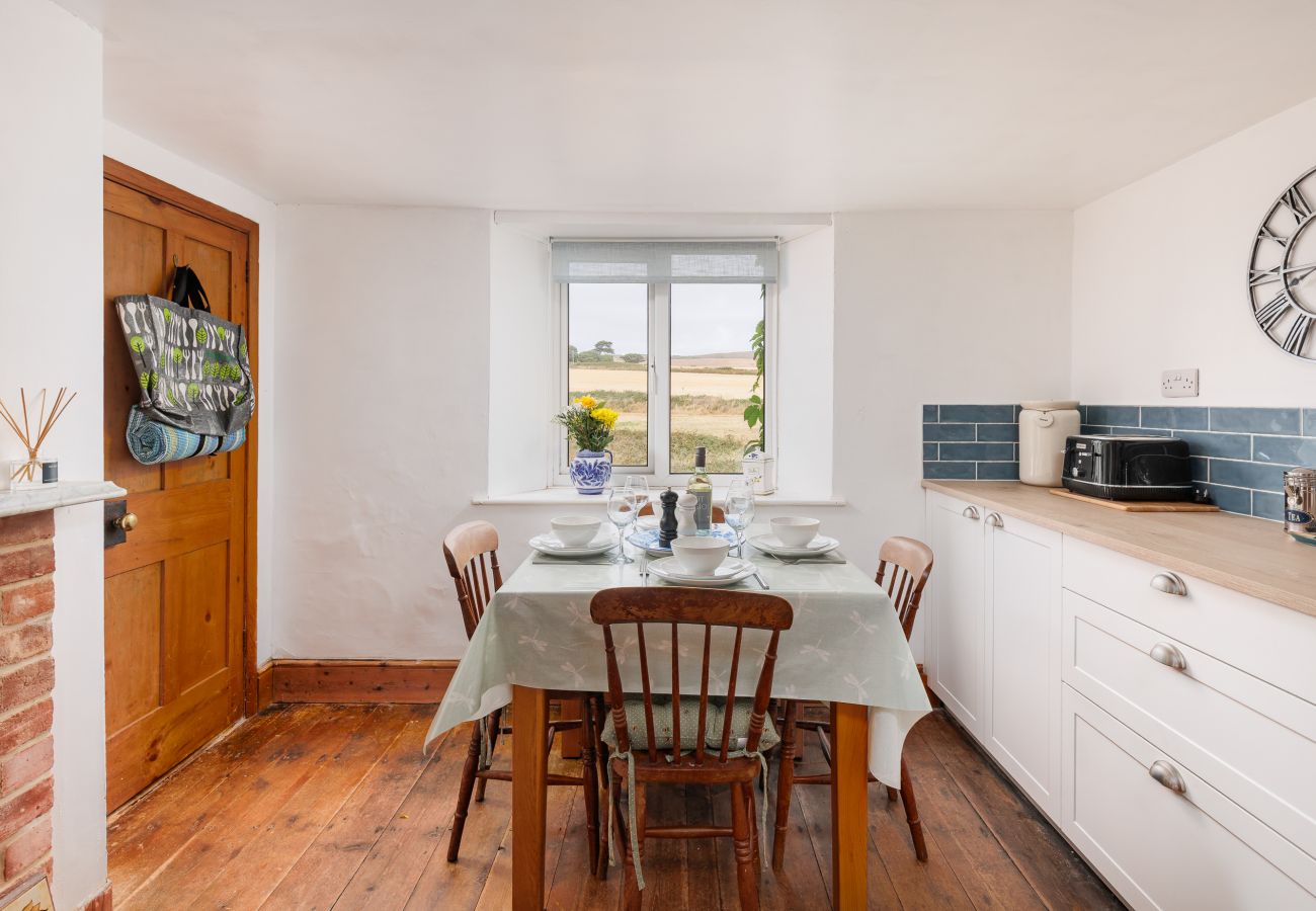 Dining table with peaceful countryside views at Moon Chine Cottage on the Isle of Wight.
