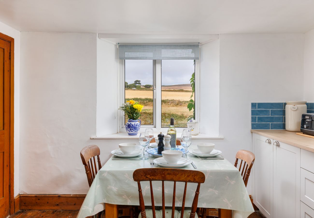 Dining table with countryside views at Moon Chine Cottage on the Isle of Wight.
