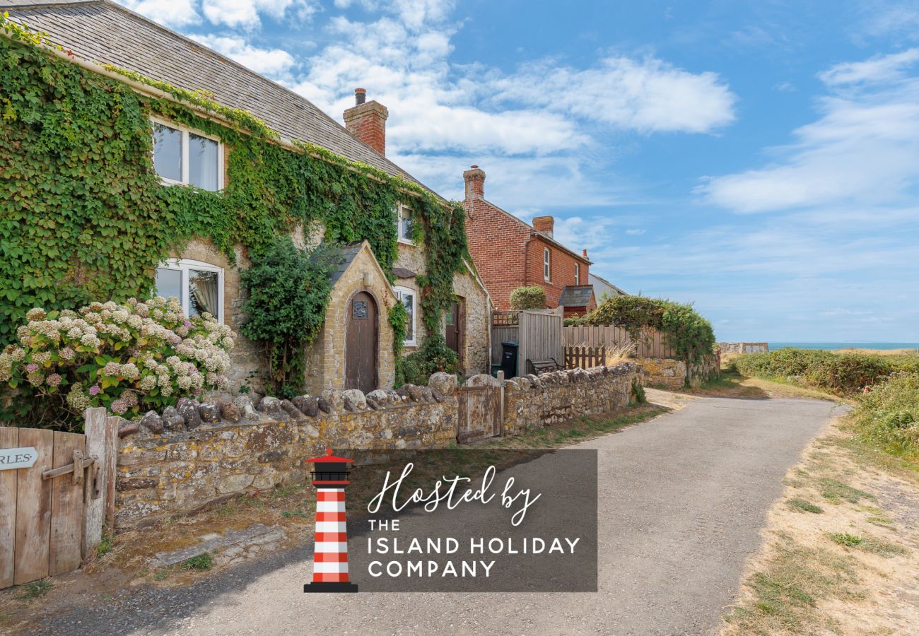 Exterior of Moon Chine Cottage with the sea visible in the background on the Isle of Wight.