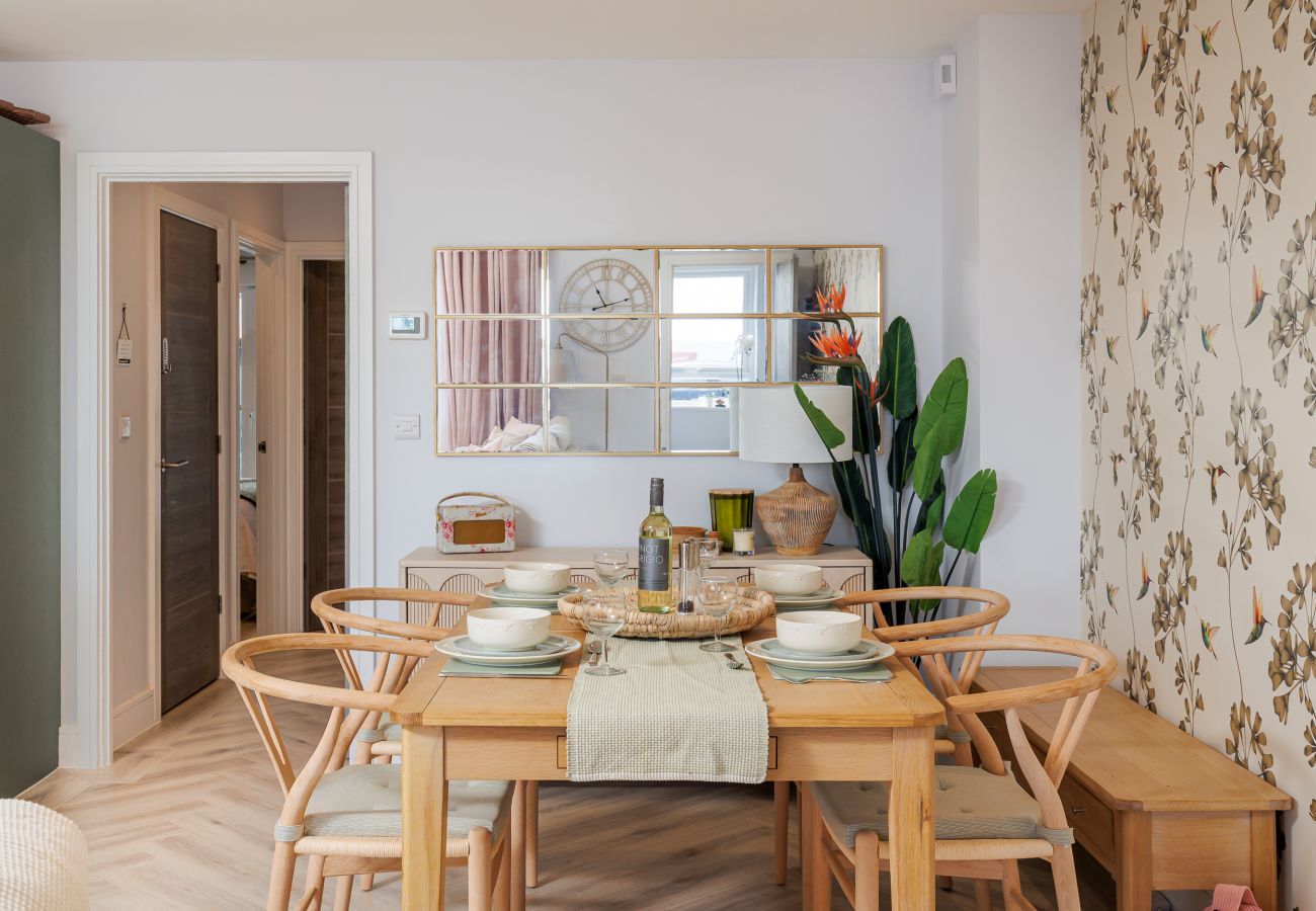 Dining table and chairs in the open-plan living area at Hummingbird, Sandown seafront.