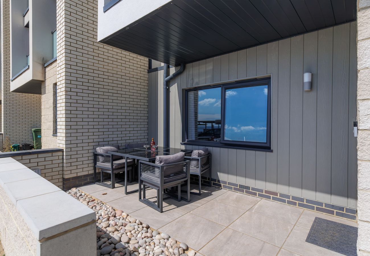 Outdoor patio with a table and chairs at Hummingbird, a ground-floor apartment on Sandown seafront, Isle of Wight.