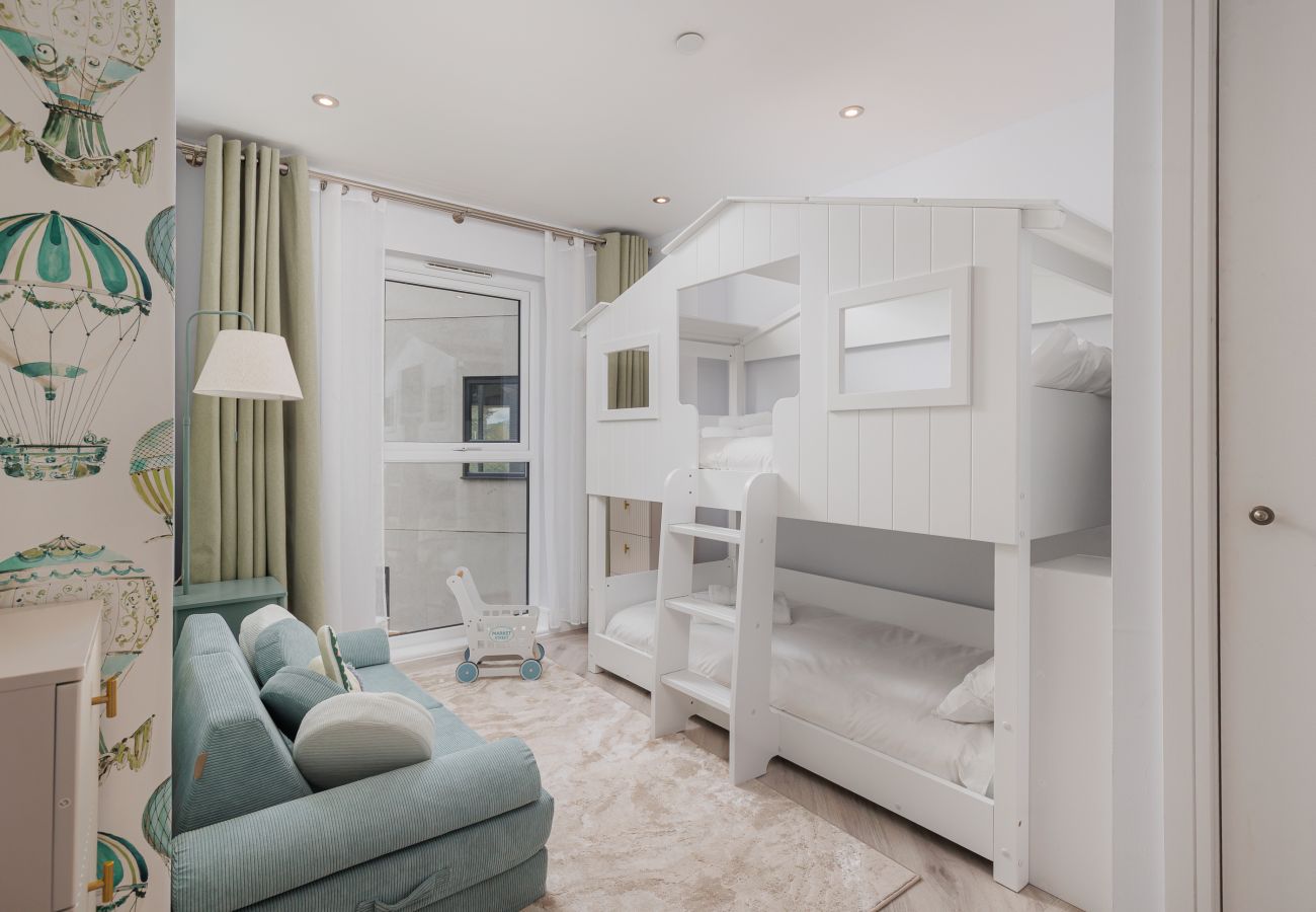 Children’s bedroom with house-style bunk beds, toys and books at Hummingbird, Sandown.