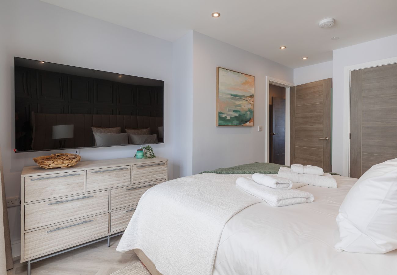 Master bedroom with super king-size bed, TV and en suite bathroom at Hummingbird on Sandown seafront.