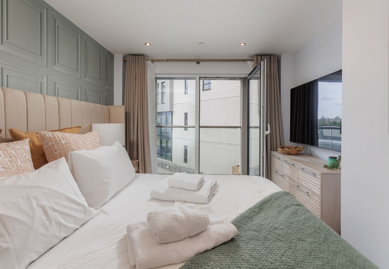 Master bedroom with super king-size bed and balcony at Hummingbird on Sandown seafront.