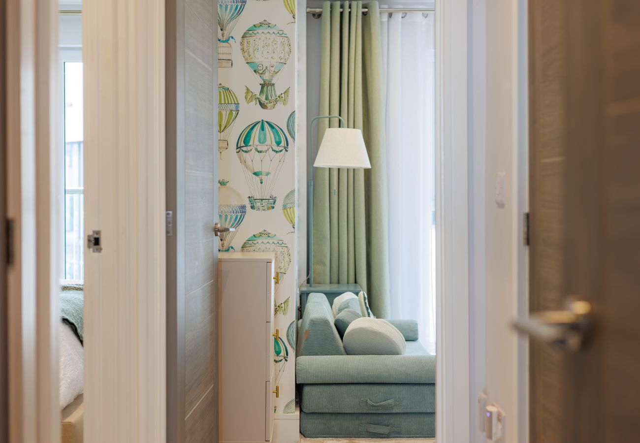 View from the hallway into the children’s bedroom, showing the house-style bunk beds and small sofa at Hummingbird.